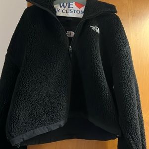 Cropped north face jacket with adjustable drawstring at bottom.